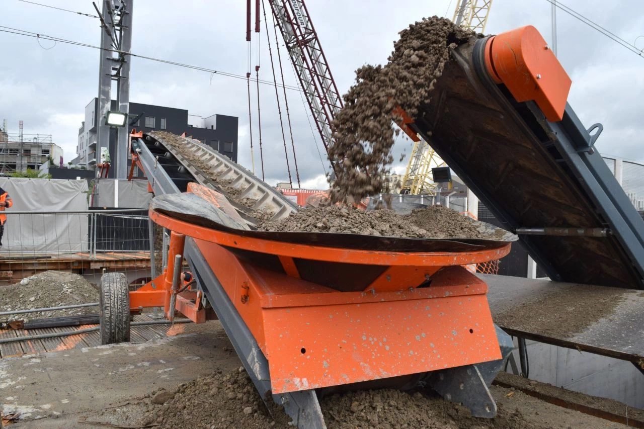 Transfert en continue de matériaux sur un chantier à l'aide d'un tapis transporteur.