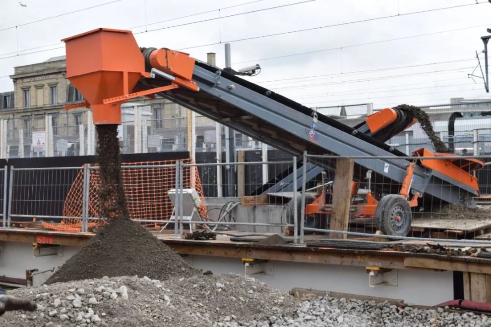 Tapis roulant pour gravats en fonctionnement sur un chantier.