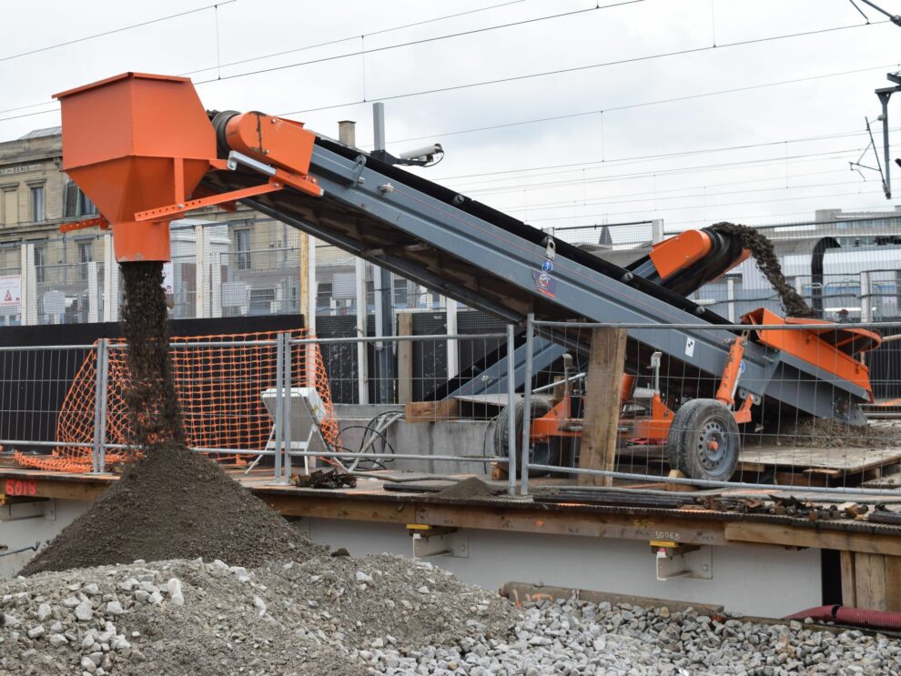 De la terre transférer d'une zone à l'autre d'un chantier à l'aide de convoyeurs.