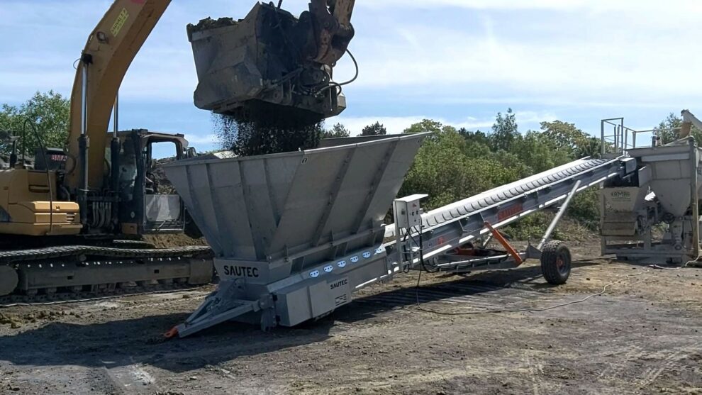 Een bouwband die wordt gebruikt om grond naar een machine te transporteren.